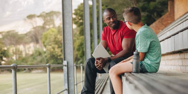 Mentor sitting with a young person, guiding them